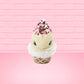 Cute kawaii bunny white ice cream cone Vanilla Pink Sprinkle with black and pink sprinkles on top with a swirl of whipped cream. This view is from the front.
