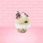 Cute kawaii bunny white ice cream cone Vanilla pink Sprinkle with black and pink sprinkles on top with a swirl of whipped cream. This view is from the other side.