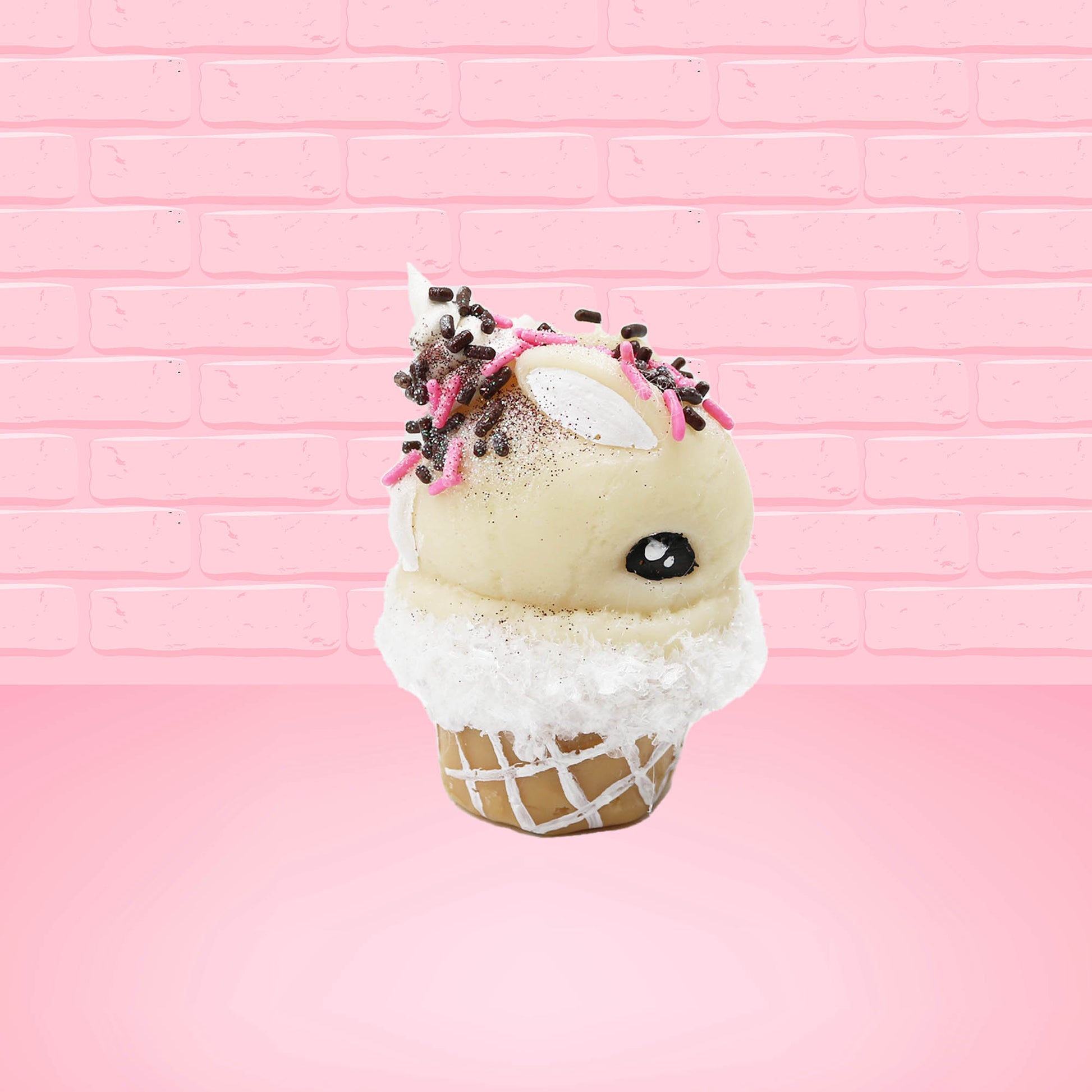 Cute kawaii bunny white ice cream cone Vanilla pink Sprinkle with black and pink sprinkles on top with a swirl of whipped cream. This view is from the other side.