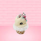 Cute kawaii bunny white ice cream cone with pink, teal, and black sprinkles on top of the bunny near the whipped cream swirl. The view is from the front at an angle. 