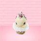 Cute kawaii bunny white ice cream cone with pink, teal, and black sprinkles on top of the bunny near the whipped cream swirl. The view is from the front. 