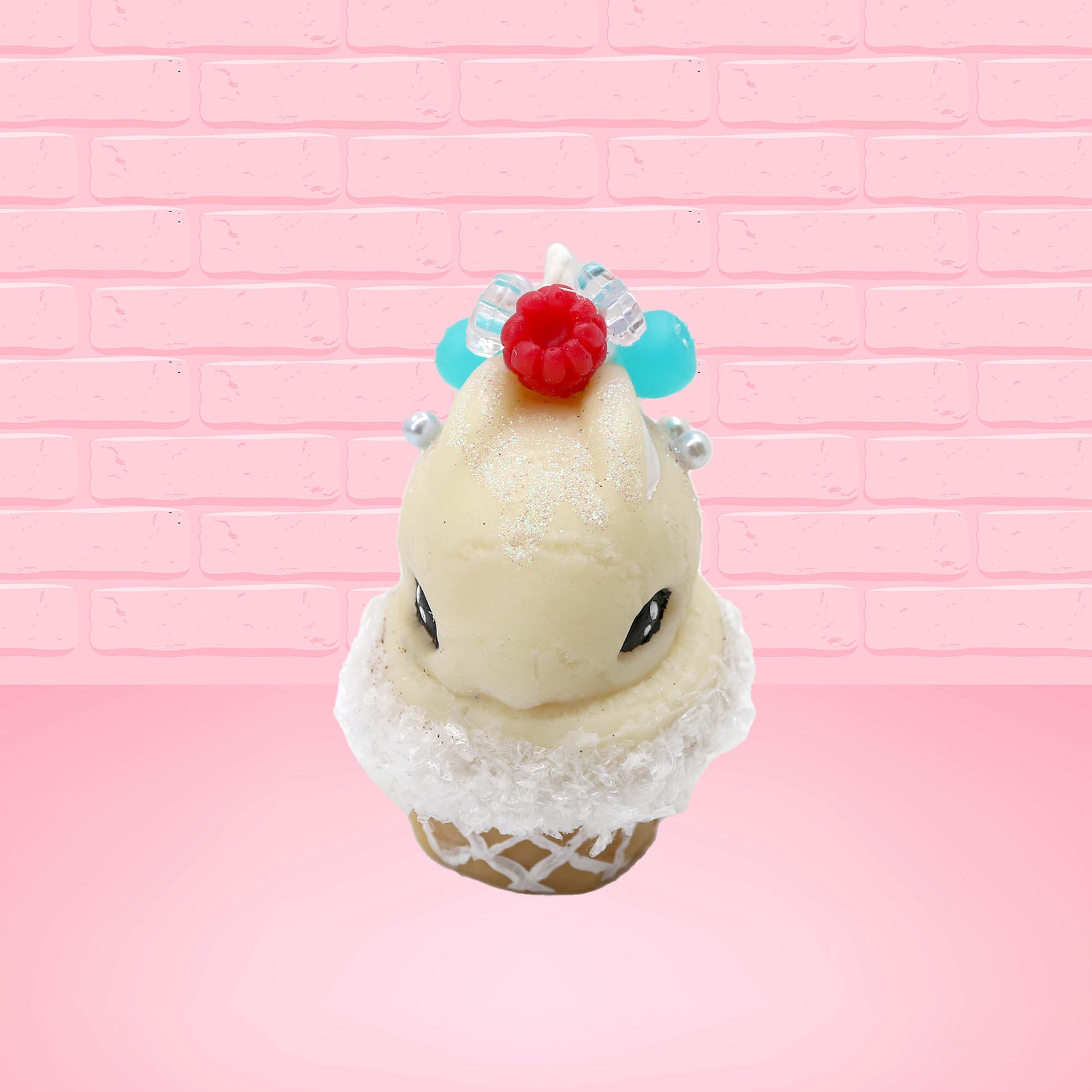 Cute kawaii bunny Vanilla Star Blast white ice cream cone with a blueberry, raspberry, and silver pearls near the swirl of whipped cream on the top of the bunny. This view is from the front.