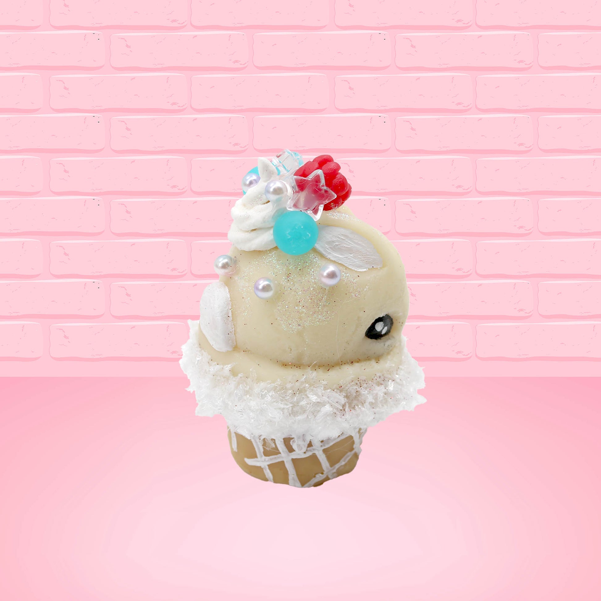 Cute kawaii bunny Vanilla Star Blast white ice cream cone with a blueberry, raspberry, and silver pearls near the swirl of whipped cream on the top of the bunny. This view is from the other side.