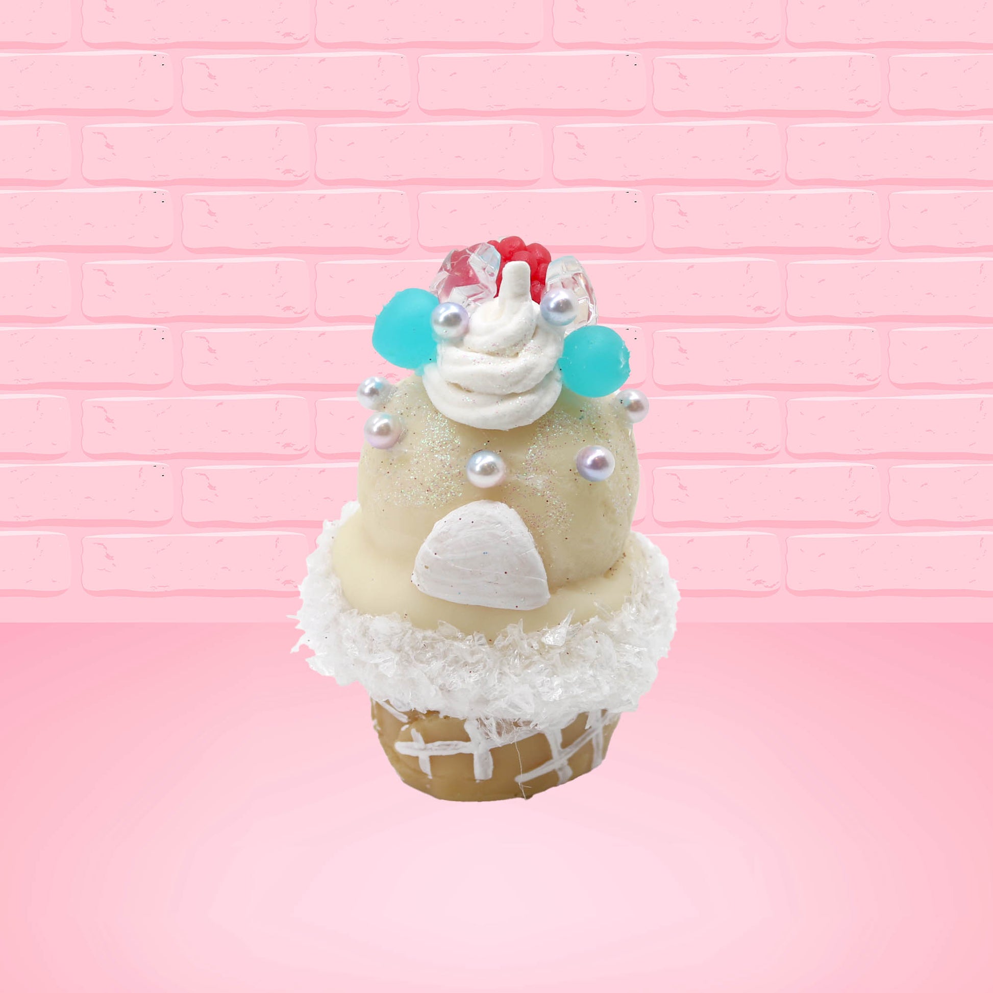 Cute kawaii bunny Vanilla Star Blast white ice cream cone with a blueberry, raspberry, and silver pearls near the swirl of whipped cream on the top of the bunny. This view is from the back.