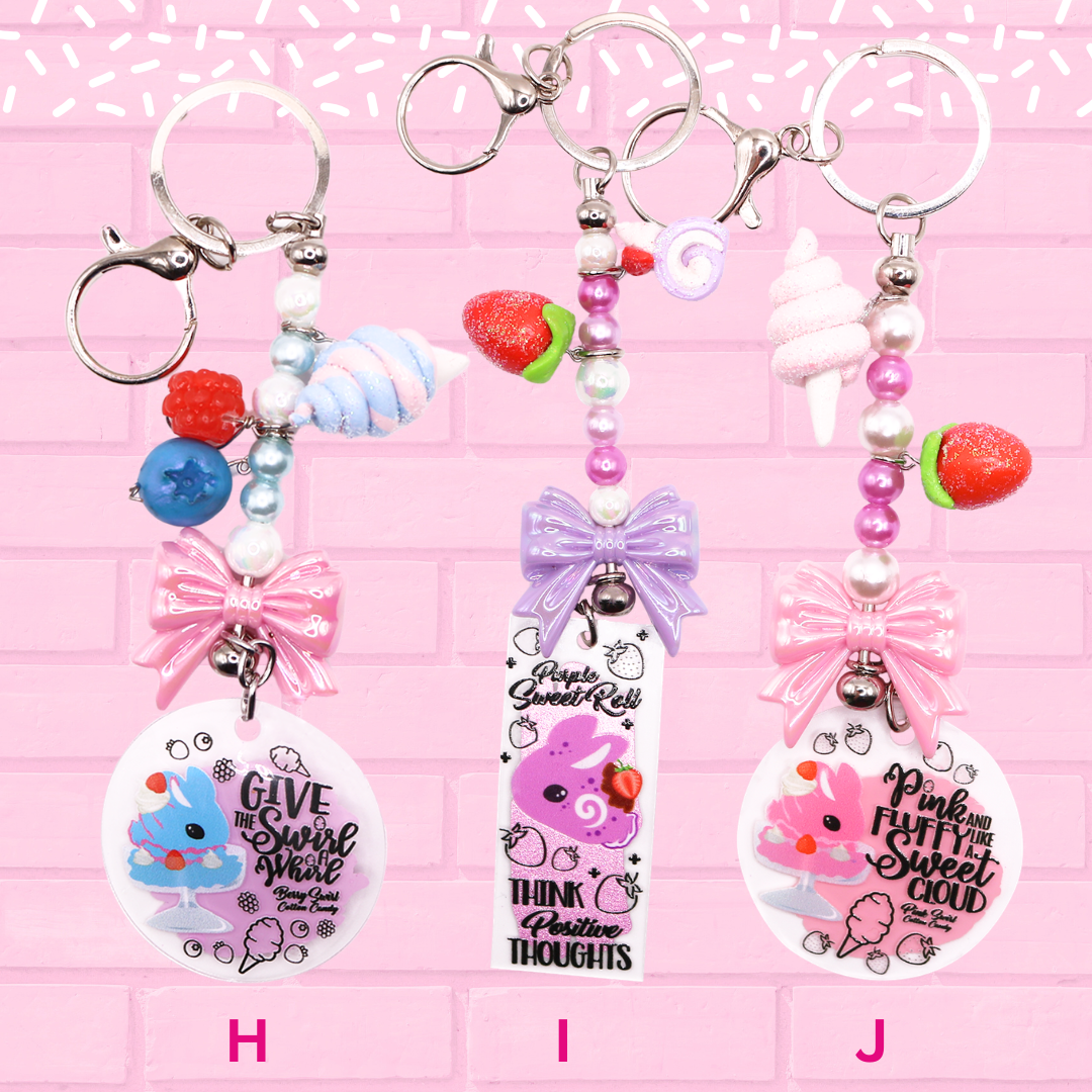 Keychain H, I, J are shown which are blue cotton candy dish, purple swirl roll, and pink cotton candy. The words Bunny Keychains Sweets & Treats 2 Inch : Medium are shown.