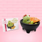 Cute kawaii green bunny with chips with red chunks and glitter in a dish. The front of the character card is also shown.
