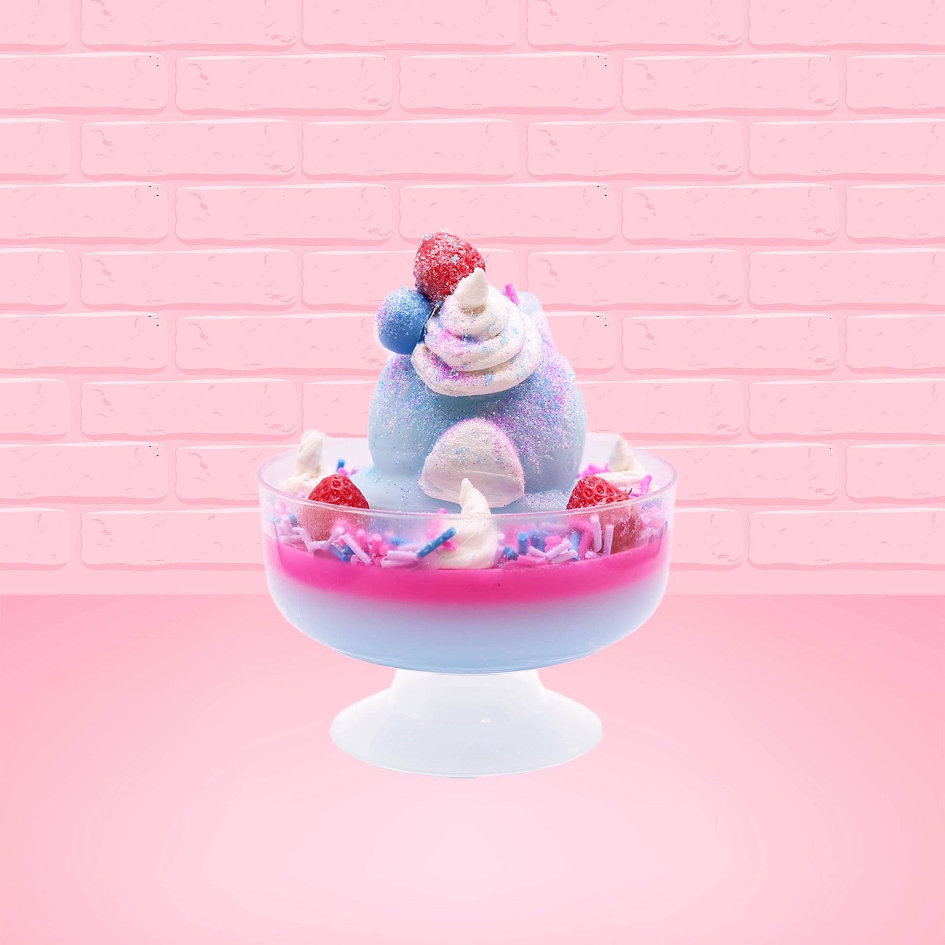 Cute kawaii Berry Swirl Cotton Candy blue ice cream sundae with pink glaze, pink blue and white sprinkles, strawberries and whipped cream swirls in the dish.  There are sprinkles, a blue berry, and strawberry on the top of the bunny near the swirl of the whipped cream. This view is from the back.