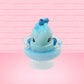 Cute kawaii Blue Berry Cotton Candy ice cream sundae with blue berries and swirls of whipped cream in the dish, while covered with blue glitter.  The bunny has two blue berries on the top near the swirl of whipped cream on the back. This view is from the front.