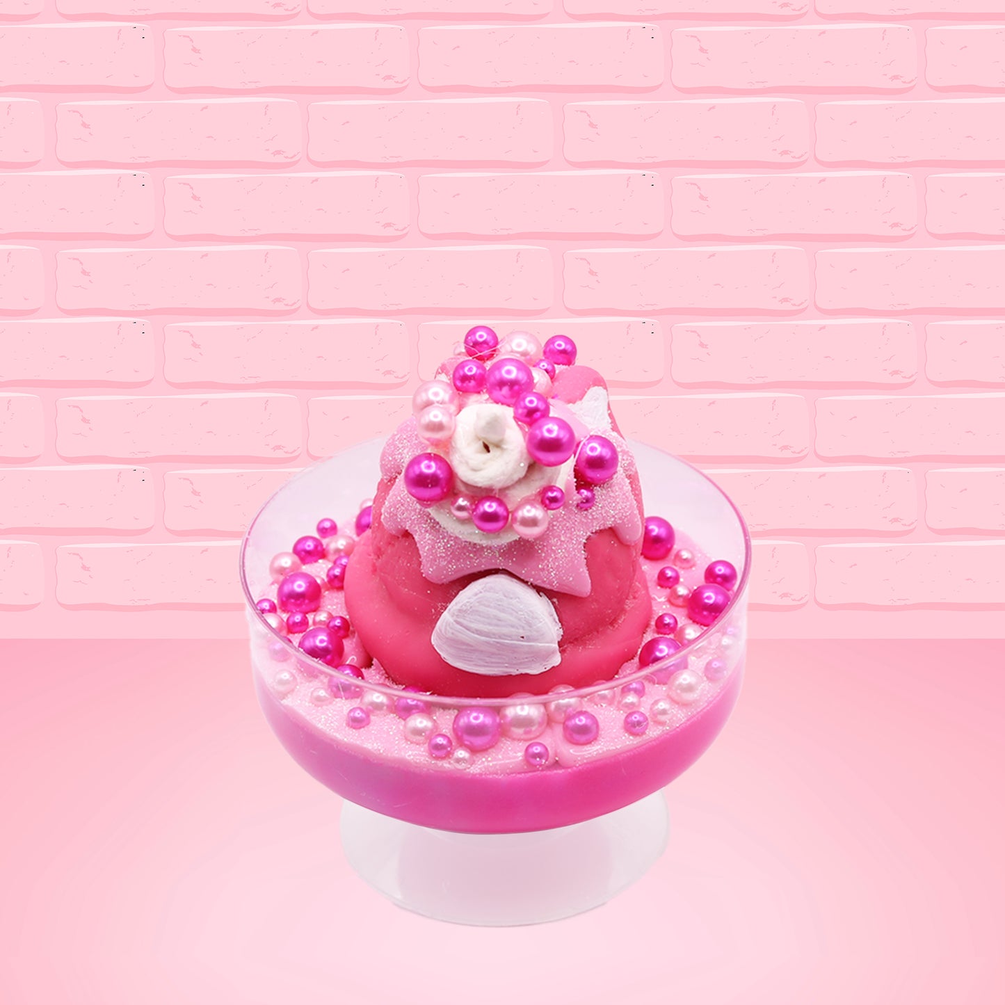 Cute kawaii bunny Bubbles pink ice cream sundae with light pink drizzle, pink and hot pink metallic spheres inside the dish. The bunny’s top is covered with the pink and hot pink spheres as well as a swirl of whipped cream. This view is from the back. 