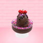 Cute kawaii bunny Chocolate Rush brown ice cream sundae with pink and purple sprinkles with swirls of whipped cream in the dish. The bunny has raspberries, chocolate glittery drizzle and sprinkles on top near the whipped cream swirl. This view is from the front.