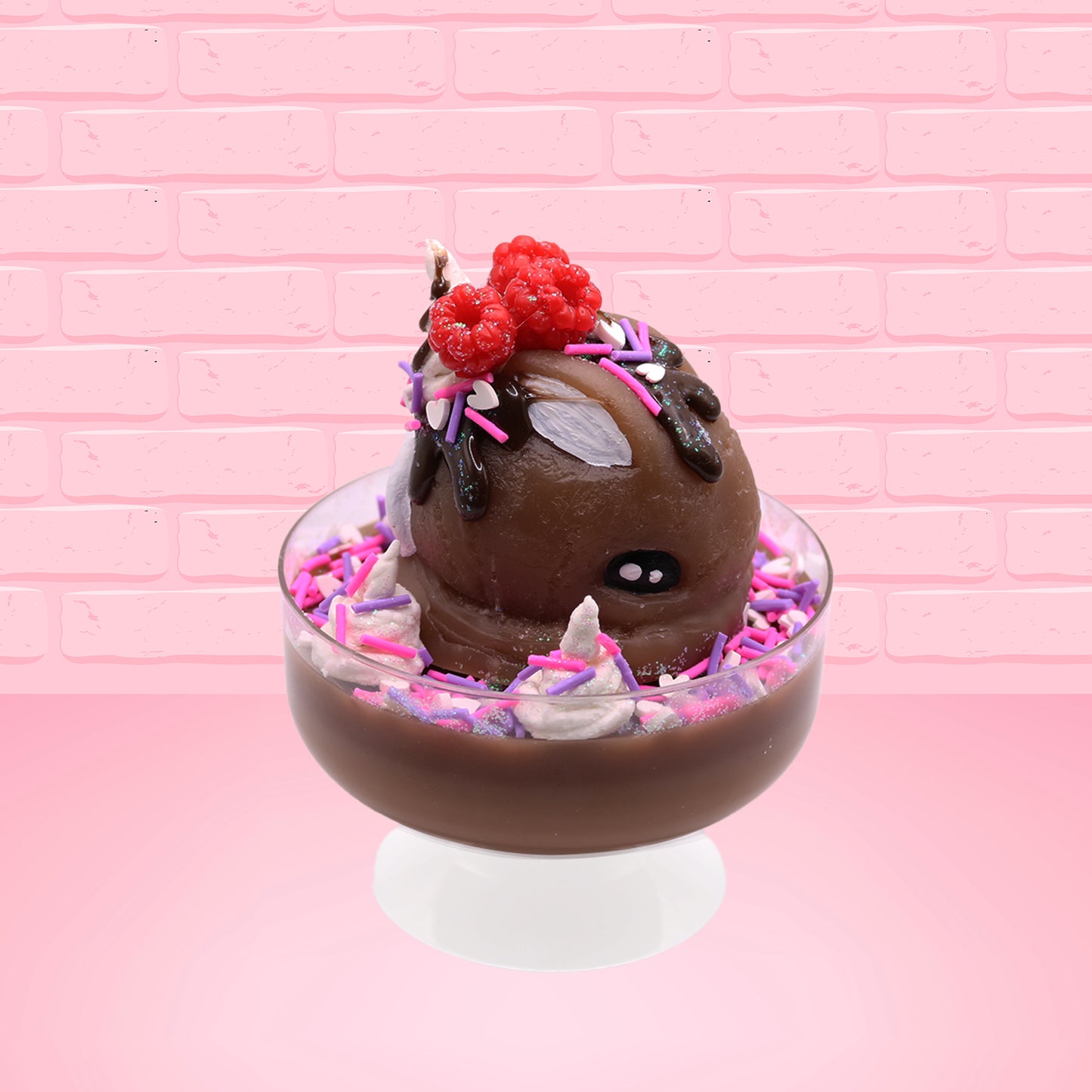 Cute kawaii bunny Chocolate Rush brown ice cream sundae with pink and purple sprinkles with swirls of whipped cream in the dish. The bunny has raspberries, chocolate glittery drizzle and sprinkles on top near the whipped cream swirl. This view is from the side.