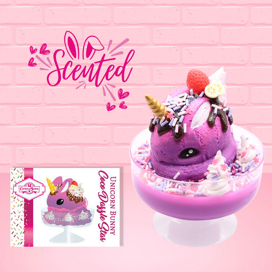 Cute kawaii unicorn bunny Coco Dazzle Star purple ice cream with pink, purple and white sprinkles with swirls of whipped cream in the dish. The unicorn bunny has a strawberry and banana slices with chocolate drizzle and sprinkles near the whipped cream swirl.  The character card front is shown and the word scented.