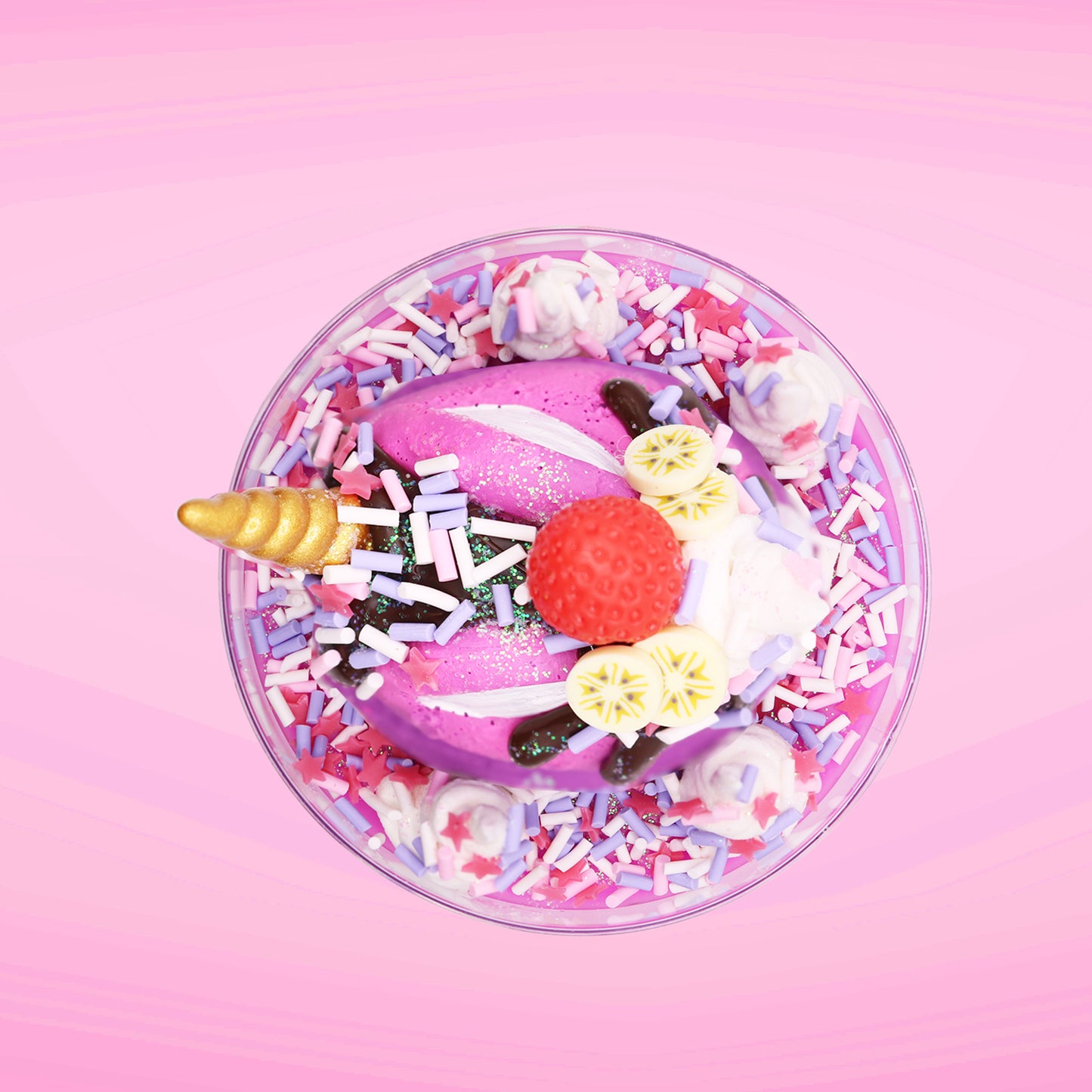 Cute kawaii unicorn bunny Coco Dazzle Star purple ice cream with pink, purple and white sprinkles with swirls of whipped cream in the dish. The unicorn bunny has a strawberry and banana slices with chocolate drizzle and sprinkles near the whipped cream swirl. This view is from the top.