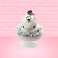 Cute kawaii bunny cookies and cream ice cream white scoop sundae with whipped cream swirls and black white crumbles in the dish. A black and white sandwhich cookie is on top of the resin bunny, sprinkled with black and white crumbles and a swirl of whipped cream. This view is from the front.
