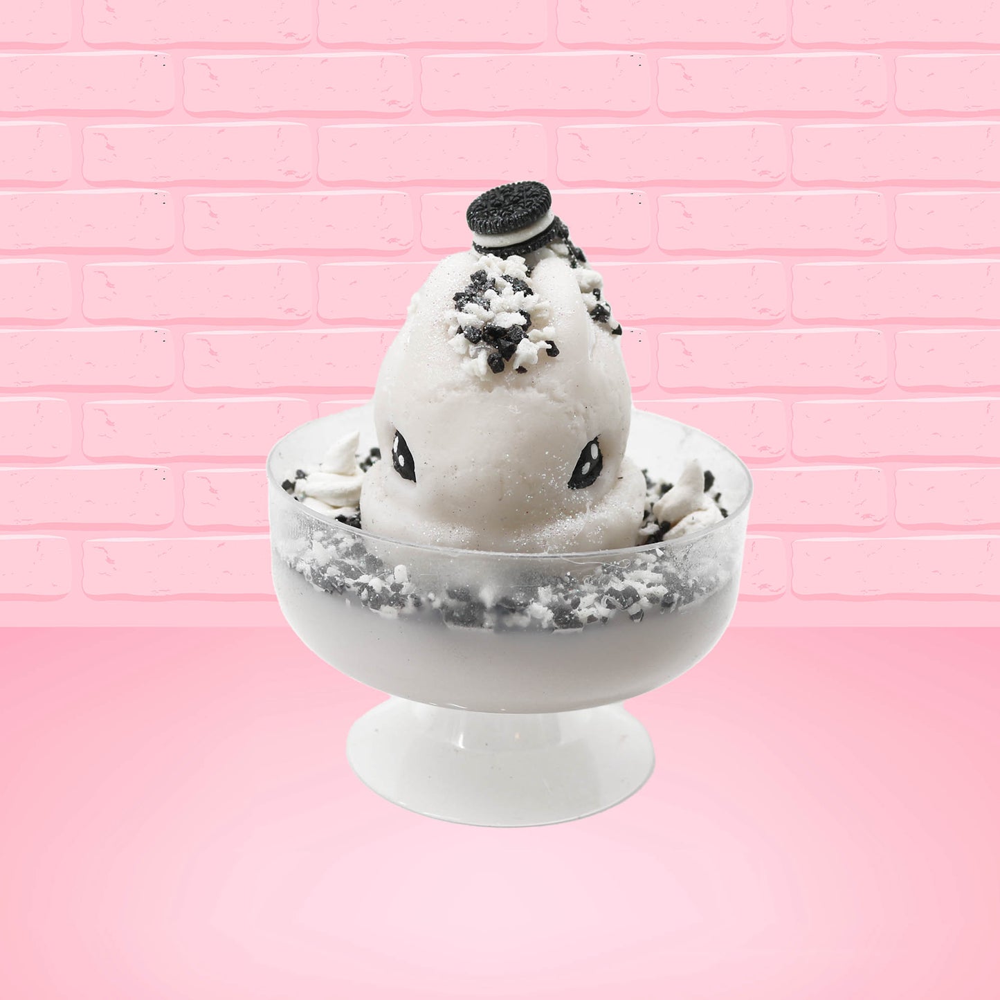 Cute kawaii bunny cookies and cream ice cream white scoop sundae with whipped cream swirls and black white crumbles in the dish. A black and white sandwhich cookie is on top of the resin bunny, sprinkled with black and white crumbles and a swirl of whipped cream. This view is from the front.
