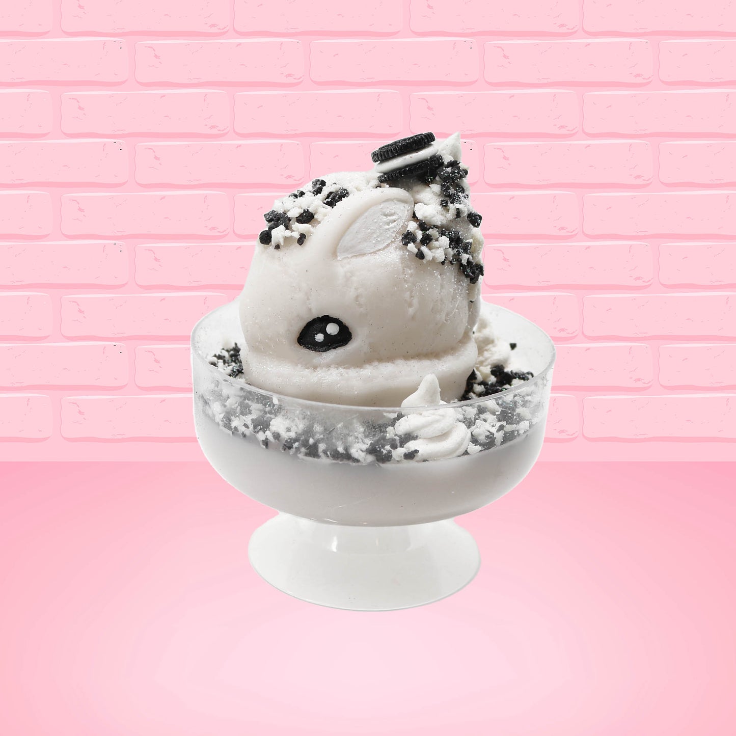 Cute kawaii bunny cookies and cream ice cream white scoop sundae with whipped cream swirls and black white crumbles in the dish. A black and white sandwhich cookie is on top of the resin bunny, sprinkled with black and white crumbles and a swirl of whipped cream. This view is from the side.