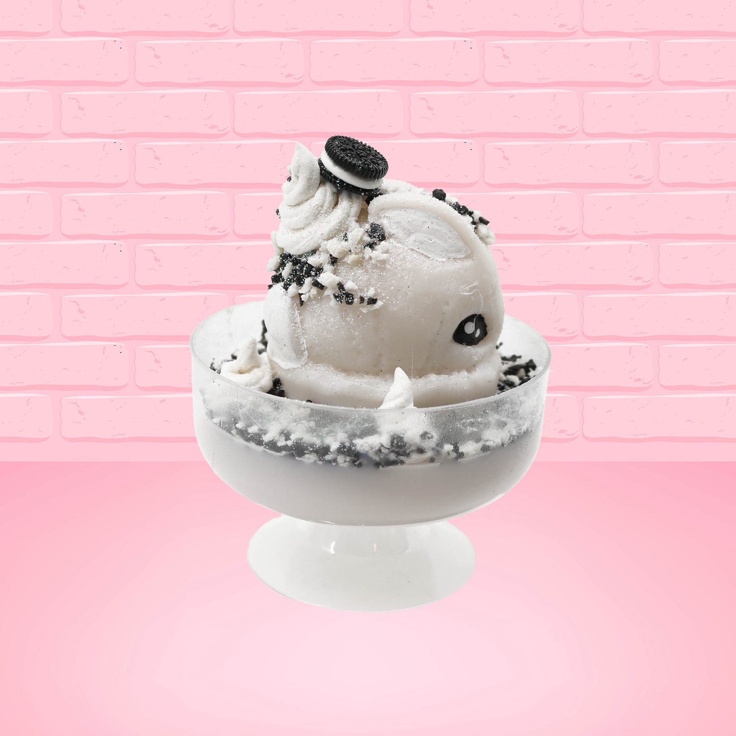 Cute kawaii bunny cookies and cream ice cream white scoop sundae with whipped cream swirls and black white crumbles in the dish. A black and white sandwhich cookie is on top of the resin bunny, sprinkled with black and white crumbles and a swirl of whipped cream. This view is from the other side.