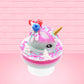 Cute kawaii unicorn bunny Irresistible Sugary Berry light blue and pink sundae with light blue and pink sprinkles with whipped cream swirls in the dish.  The unicorn bunny has blue berries and red raspberries on top near the whipped cream swirl with white drizzle coming down. This view is from the side.