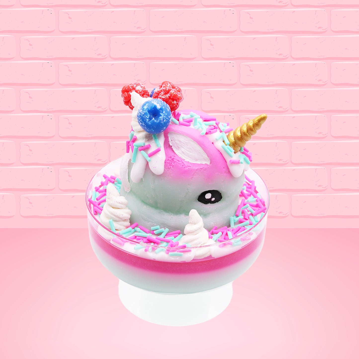 Cute kawaii unicorn bunny Irresistible Sugary Berry light blue and pink sundae with light blue and pink sprinkles with whipped cream swirls in the dish.  The unicorn bunny has blue berries and red raspberries on top near the whipped cream swirl with white drizzle coming down. This view is from the side.