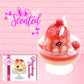 Cute kawaii bunny new strawberry cheesecake white ice cream with red translucent glaze, strawberries, and swirls of whipped cream in the dish. The bunny has red glittery glaze dripping over the head with a strawberry and a swirl of whipped cream on top. The character card front is shown, with the word scented.