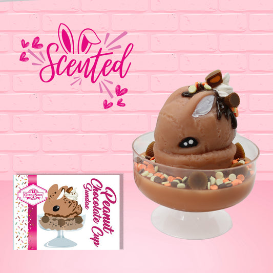 Cute kawaii peanut chocolate cup resin ice cream sundae with orange and white sprinkles in the dish. Chocolate drizzle and cups are on the top of the resin ice cream bunny, and a swirl whipped cream on top. Shows the character card and that the item is scented.