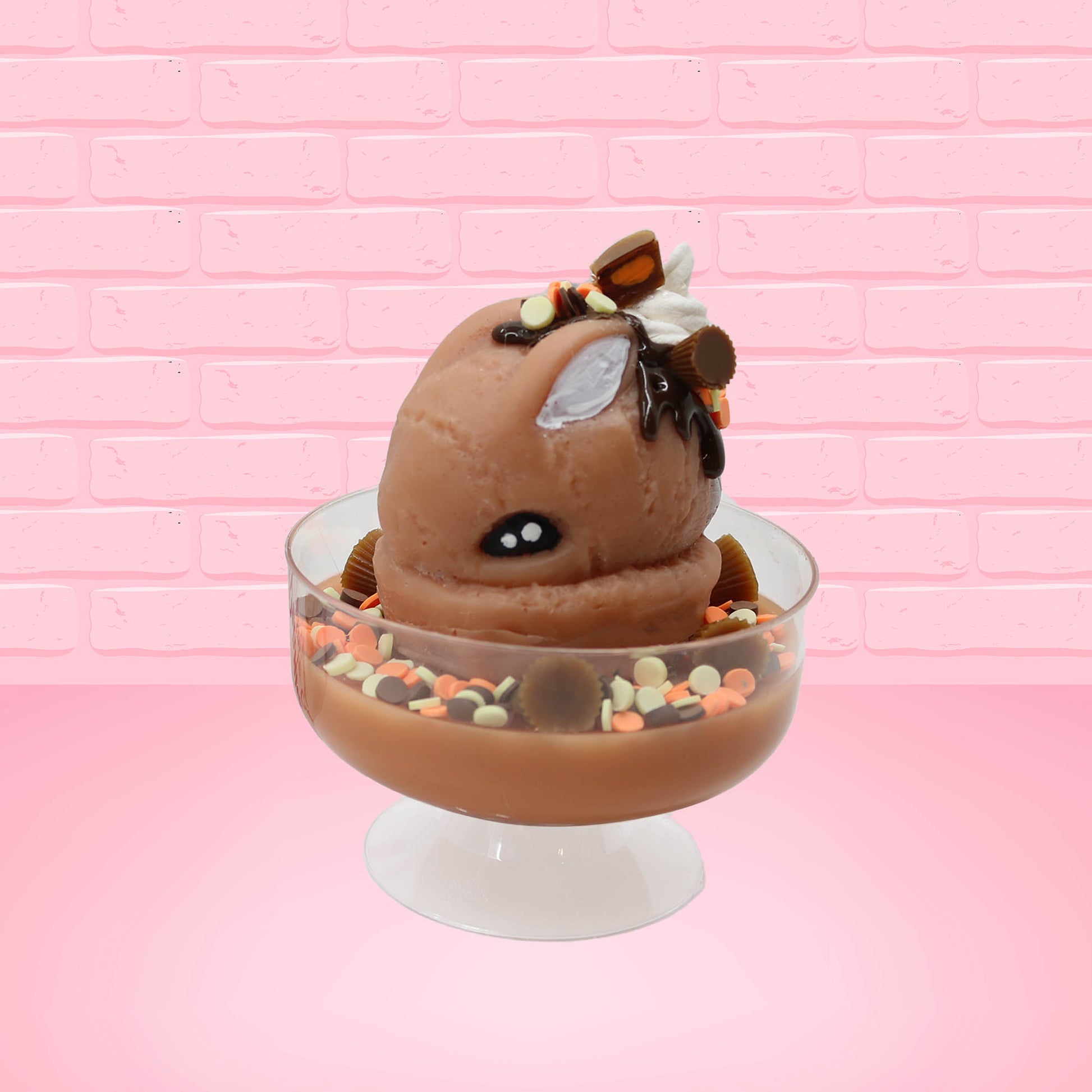 Cute kawaii peanut chocolate cup resin ice cream sundae with orange and white sprinkles in the dish. Chocolate drizzle and cups are on the top of the resin ice cream bunny, and a swirl whipped cream on top isometrically.