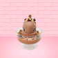 Cute kawaii peanut chocolate cup resin ice cream sundae with orange and white sprinkles in the dish. Chocolate drizzle and cups are on the top of the resin ice cream bunny, and a swirl whipped cream on top from the front.