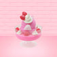 Cute kawaii bunny Pink Swirl Cotton Candy pink ice cream sundae with strawberries and swirls of whipped cream in the dish. The bunny has two strawberries near the swirl of whipped cream on top and white glitter.   This view is from the back.