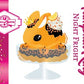Cute kawaii ice cream bunny sundae character card front which shows the digital artwork. This artwork shows Pumpkin King Night Fright orange ice cream sundae with black glaze, orange sprinkles and pumpkin faces in the dish.  The bunny has a golden crown and orange slice on top next to the swirl of whipped cream.