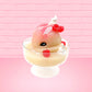 Cute kawaii bunny raspberry cheesecake white ice cream with raspberries and whipped cream swirls in the dish. The bunny has two raspberry on the back near the swirl of whipped cream and covered with white glitter. This view is from the side.