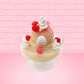 Cute kawaii bunny raspberry cheesecake white ice cream with raspberries and whipped cream swirls in the dish. The bunny has two raspberry on the back near the swirl of whipped cream and covered with white glitter. This view is from the back.