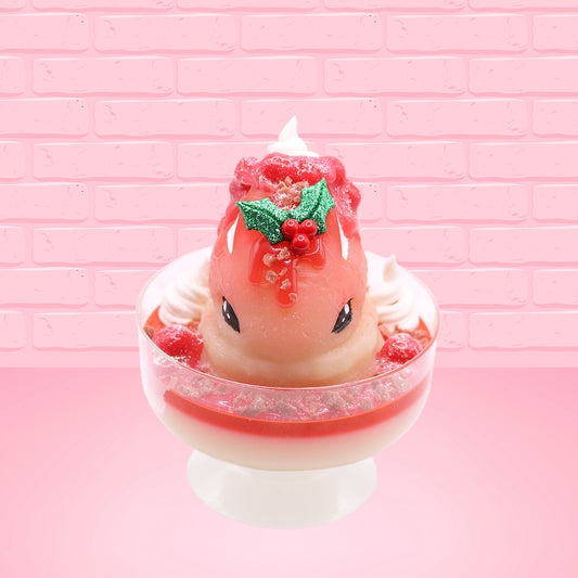 Cute kawaii bunny Santa Cookie Crumble white ice cream sundae with red glaze, glitter, red berries and whipped swirls in the dish. The bunny has red berries and green leaves on top with red translucent glaze near the whipped cream swirl. This view is from the front.