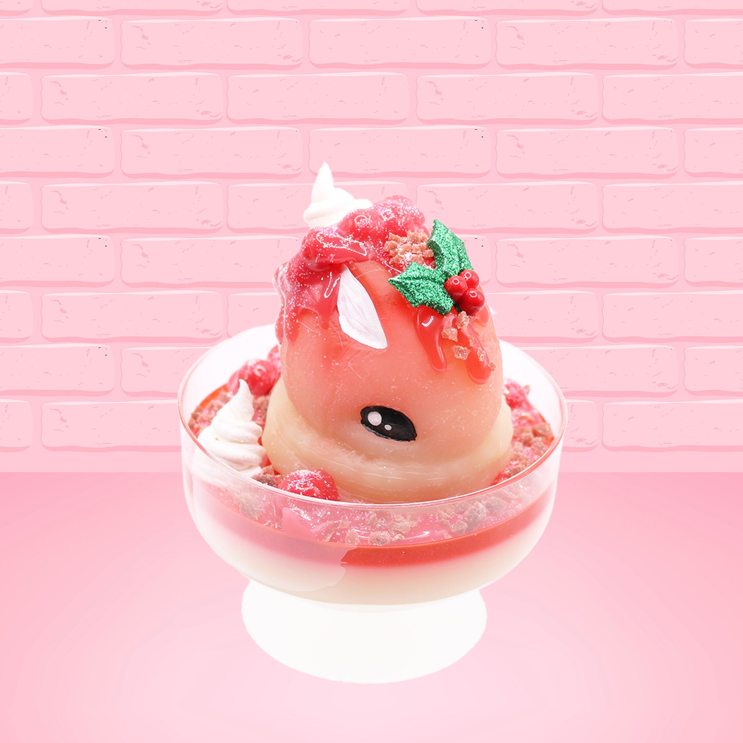 Cute kawaii bunny Santa Cookie Crumble white ice cream sundae with red glaze, glitter, red berries and whipped swirls in the dish. The bunny has red berries and green leaves on top with red translucent glaze near the whipped cream swirl. This view is from the front at an angle.