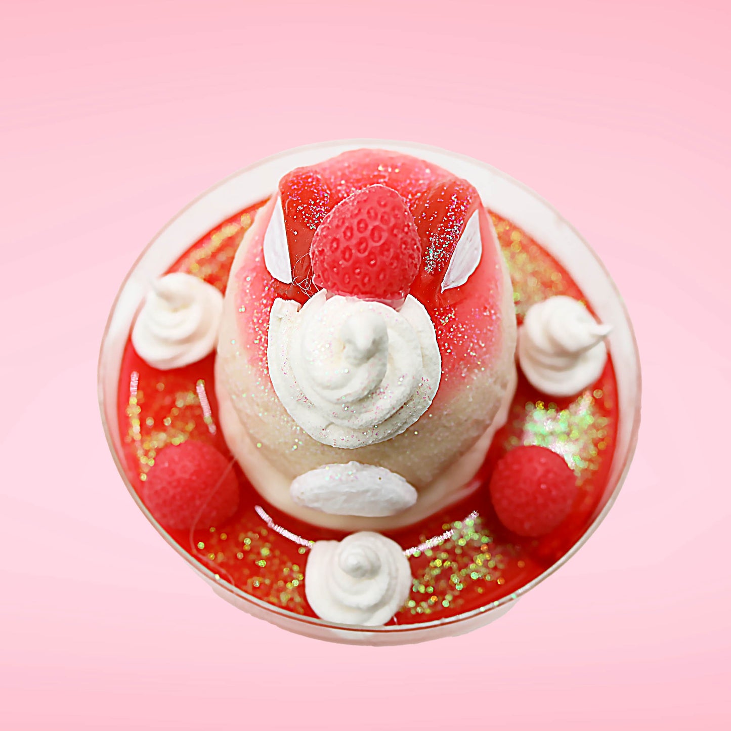 Cute kawaii bunny strawberry cheesecake white ice cream with red glaze, strawberries, and whipped cream swirls in the dish. The bunny has a strawberry on top between the ears, with a swirl of whipped cream on the back. This view is from the top.