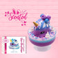 Cute kawaii unicorn bunny ice cream Sugar Berry Twilight sundae with whipped cream swirls, pink, blue, and white sprinkles in the dish. The unicorn bunny is purple and blue on top with blue berries and light purple raspberries, with a whipped cream swirl. The front of the character card is shown with the word scented.