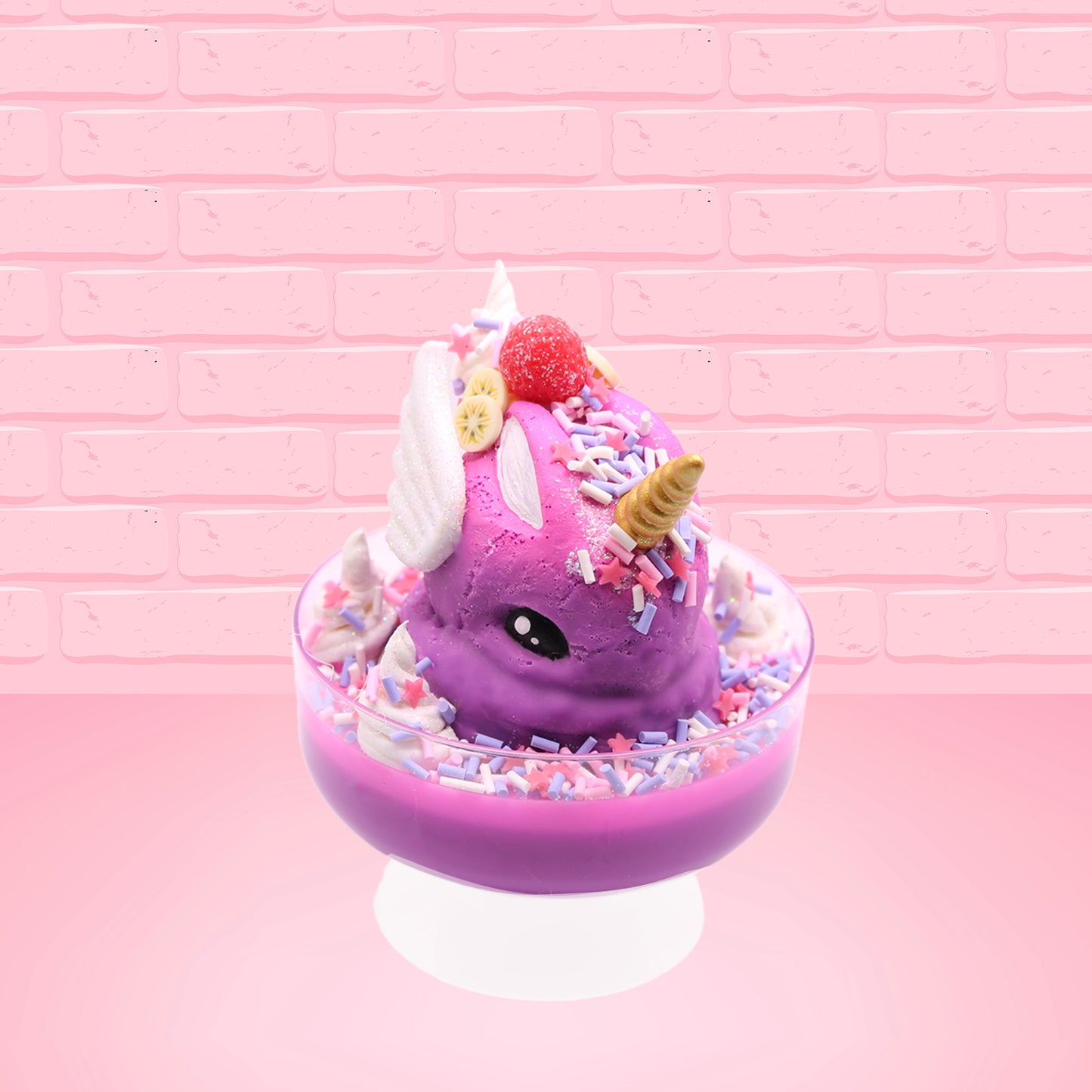 Cute kawaii unicorn purple and pink ice cream sundae with whipped cream swirls, purple, pink, white, and red star sprinkles in the dish. This unicorn bunny has white wings with a strawberry, banana slices and sprinkles on top near the whipped cream. This view is from the front at an angle.