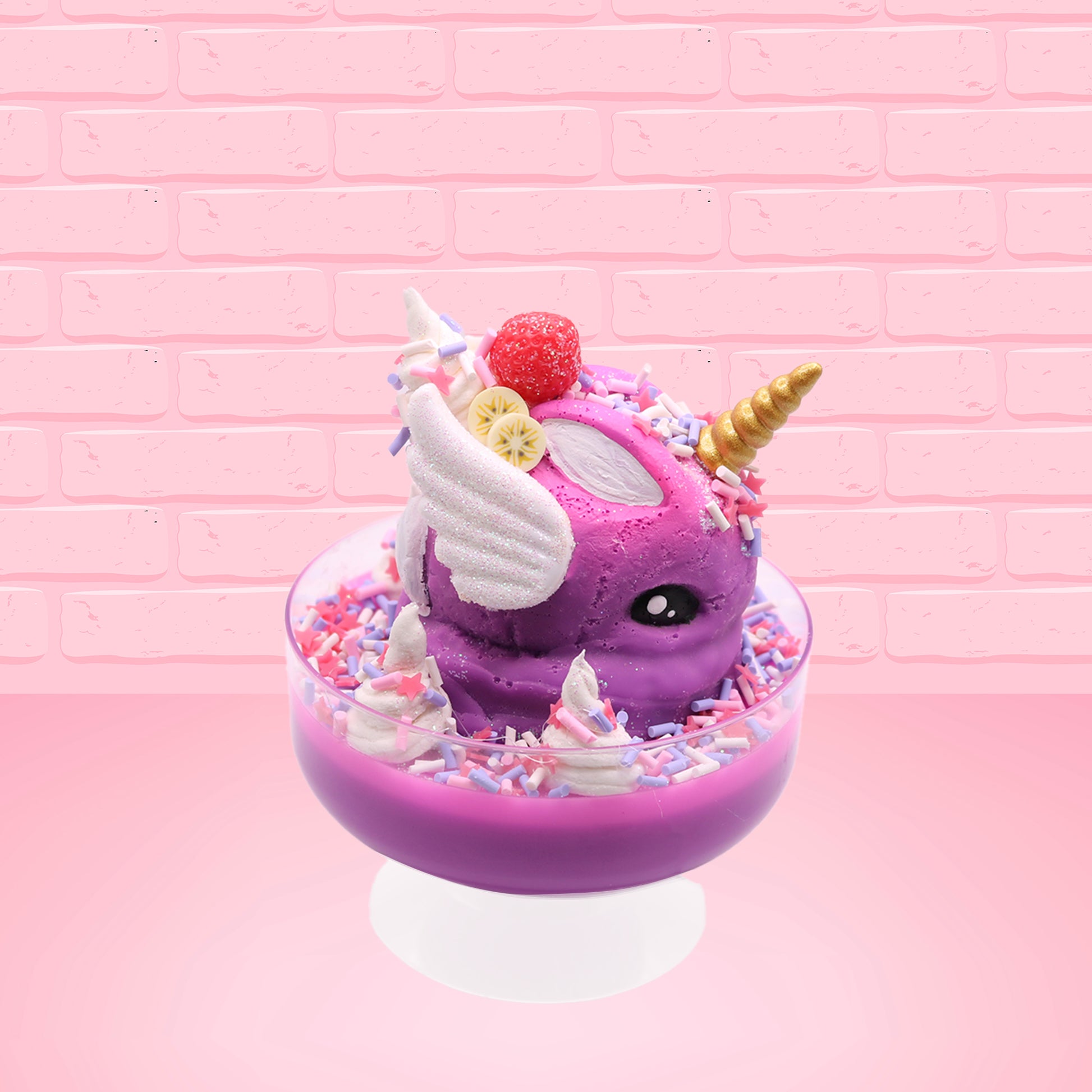 Cute kawaii unicorn purple and pink ice cream sundae with whipped cream swirls, purple, pink, white, and red star sprinkles in the dish. This unicorn bunny has white wings with a strawberry, banana slices and sprinkles on top near the whipped cream. This view is from the other side. 