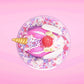 Cute kawaii unicorn purple and pink ice cream sundae with whipped cream swirls, purple, pink, white, and red star sprinkles in the dish. This unicorn bunny has white wings with a strawberry, banana slices and sprinkles on top near the whipped cream. This view is from the top. 