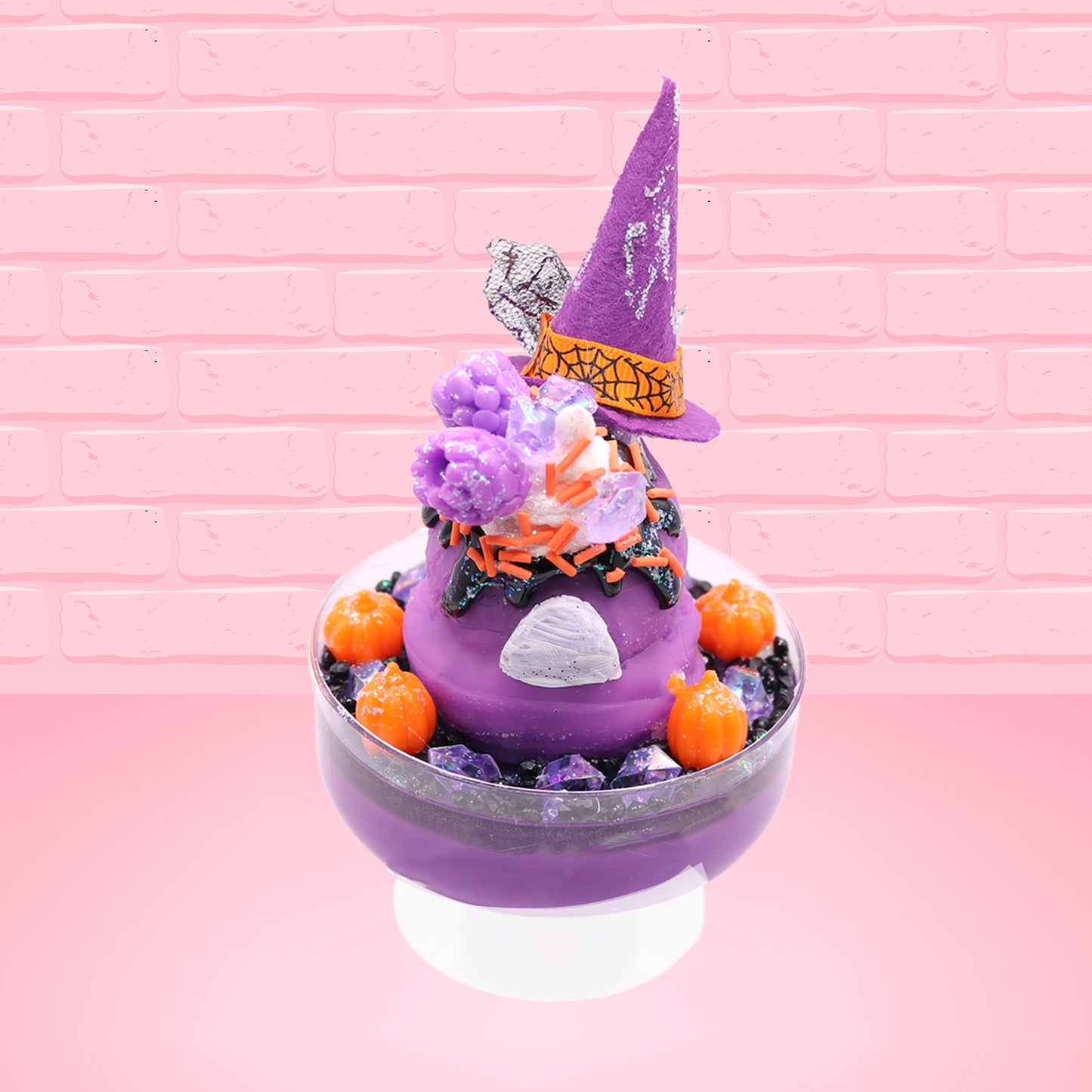 Cute kawaii witch bunny Blair purple ice cream with purple crystals and pumpkins on top of a layer of glittery black translucent layer. The bunny has a purple witch’s hat, with purple raspberries and a whipped cream swirl on top, with black glittery glaze and orange sprinkles. This view is from the back.