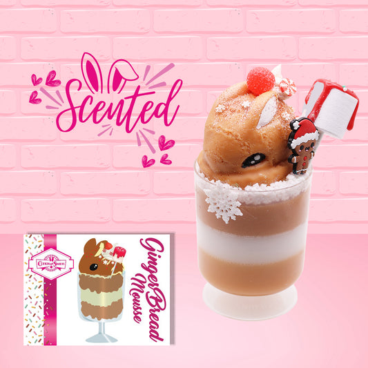 Cute kawaii bunny Gingerbread Mousse tall ice cream sundae that has white crumbles, a gingerbread man with a santa hat, and a marshmallow with glittery red glaze in the dish.  The bunny has peppermint candies, a strawberry, and a swirl of whipped cream on top and a snowflake on the front. The character card front is shown and the word scented. 