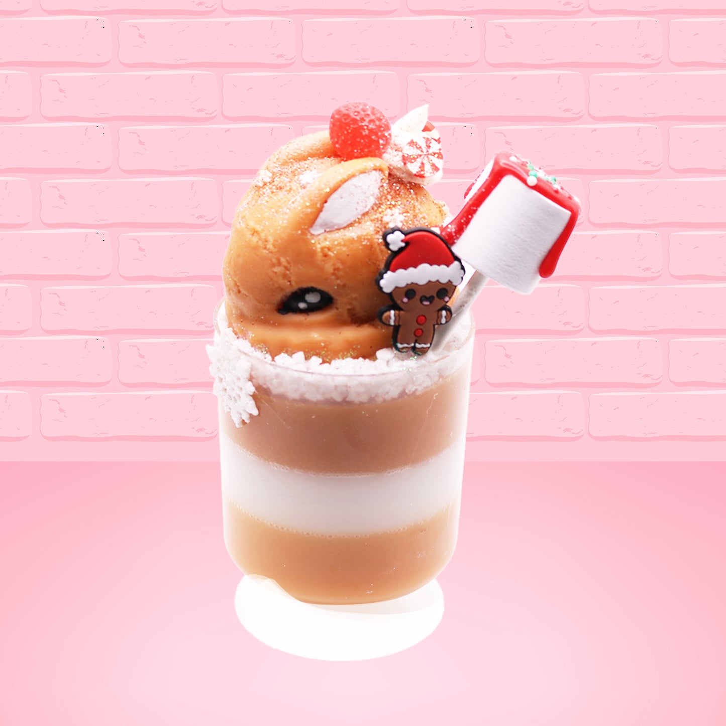 Cute kawaii bunny Gingerbread Mousse tall ice cream sundae that has white crumbles, a gingerbread man with a santa hat, and a marshmallow with glittery red glaze in the dish.  The bunny has peppermint candies, a strawberry, and a swirl of whipped cream on top and a snowflake on the front. This view is from the other side. 
