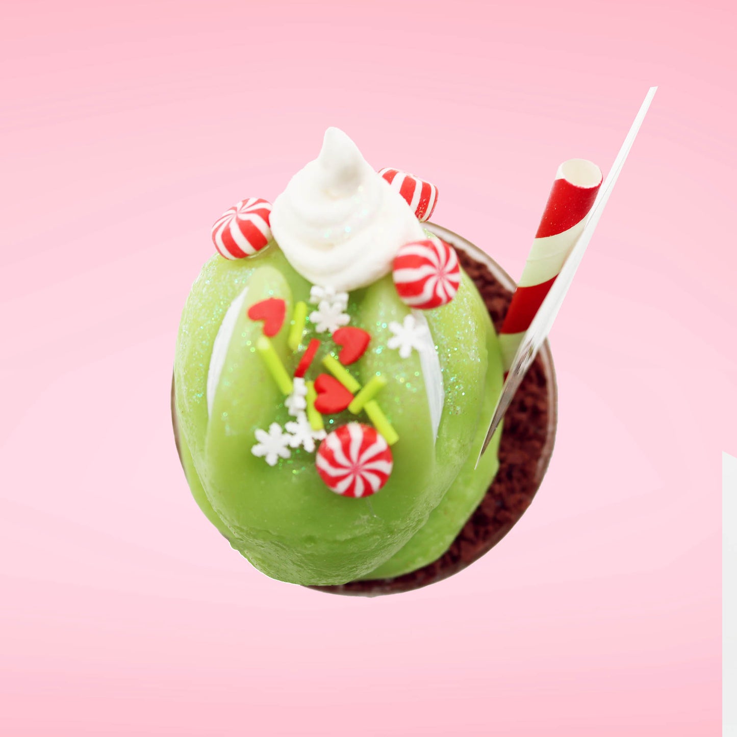 Cute kawaii bunny green Grinch Brownie tall sundae with brown sprinkles in the cup as well as a sign that reads don’t be a grinch.  The ice cream bunny has peppermint candies, green and white sprinkles as well as a swirl of whipped cream on top. This view is from the top. 