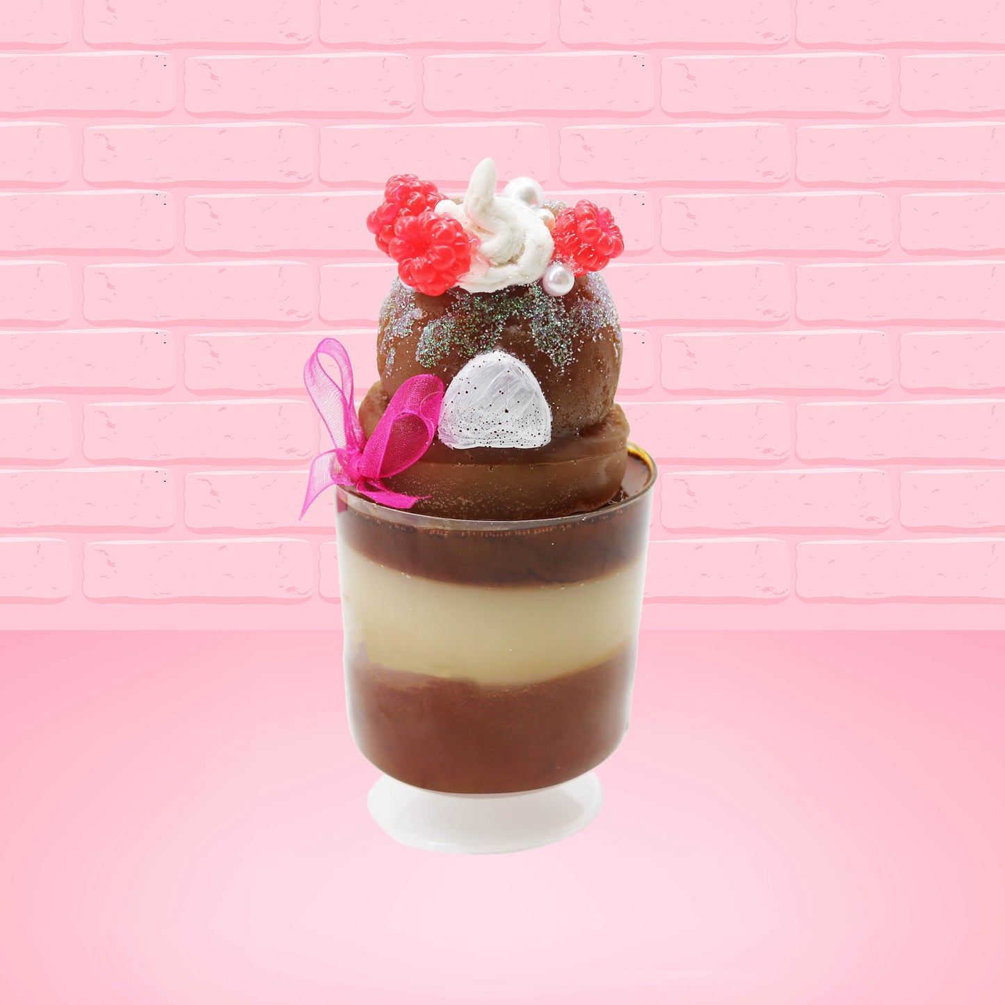 Cute kawaii bunny tall brown Hot Fudge ice cream sundae with glitter and raspberries on top with the whipped cream swirl. The bunny has white pearls and a pink ribbon. This view is from the back.