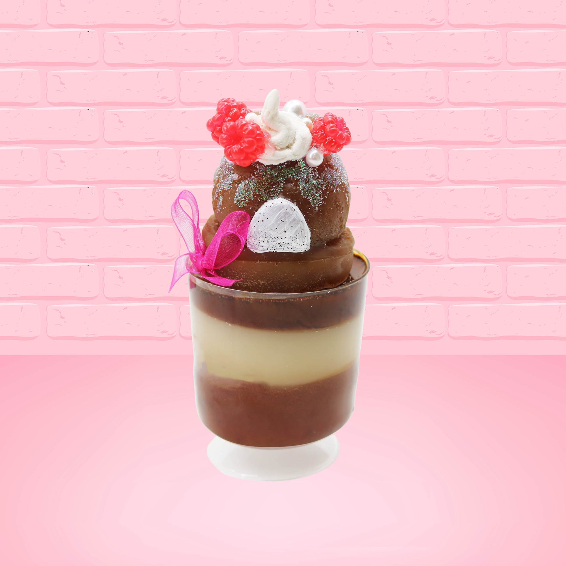 Cute kawaii bunny tall brown Hot Fudge ice cream sundae with glitter and raspberries on top with the whipped cream swirl. The bunny has white pearls and a pink ribbon. This view is from the back.