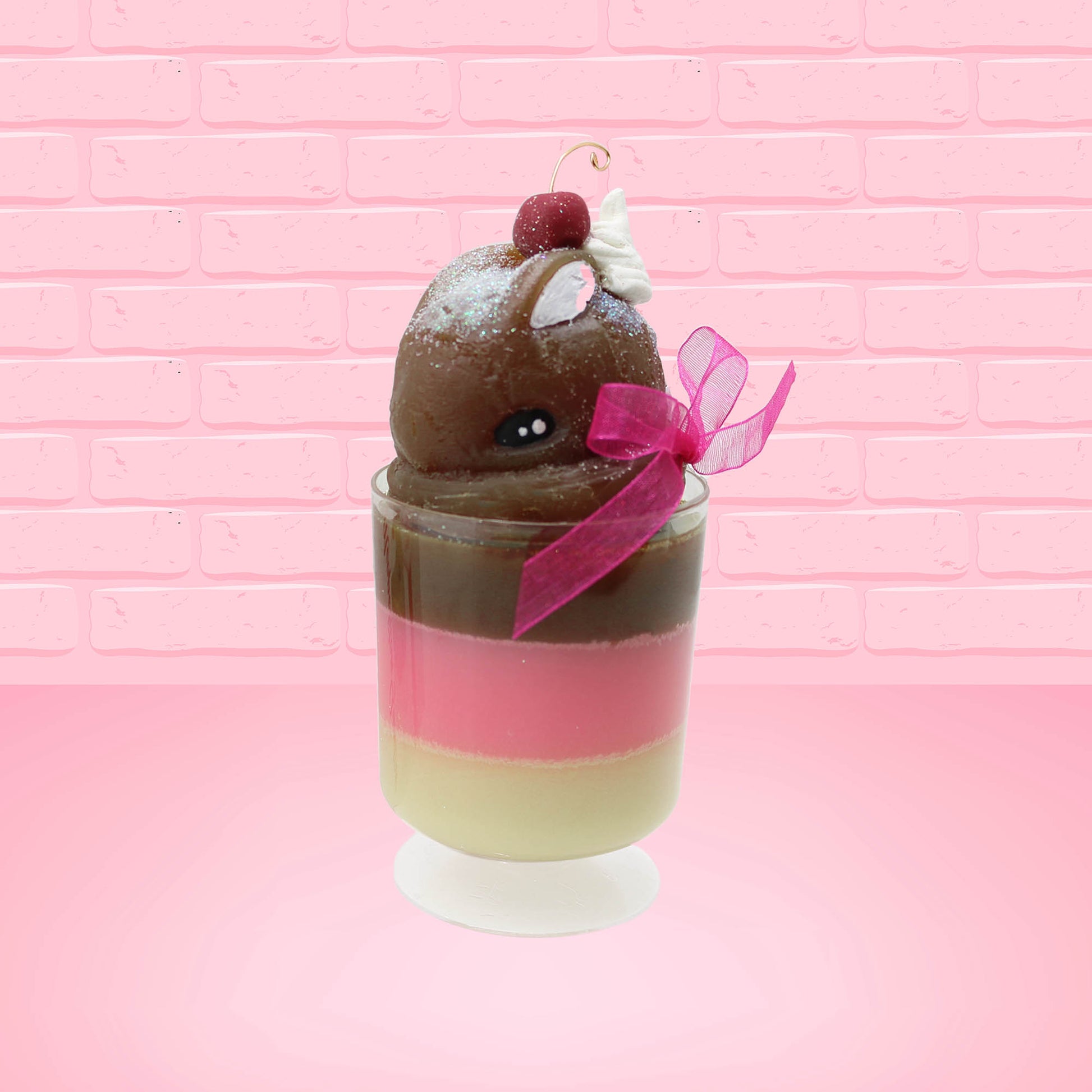 Cute Kawaii bunny tall Neapolitan three layered ice cream sundae with a cherry and swirl of whipped cream on top.  The top of the bunny is covered with white glitter, and has a pink bow.  This view is from the front at an angle.