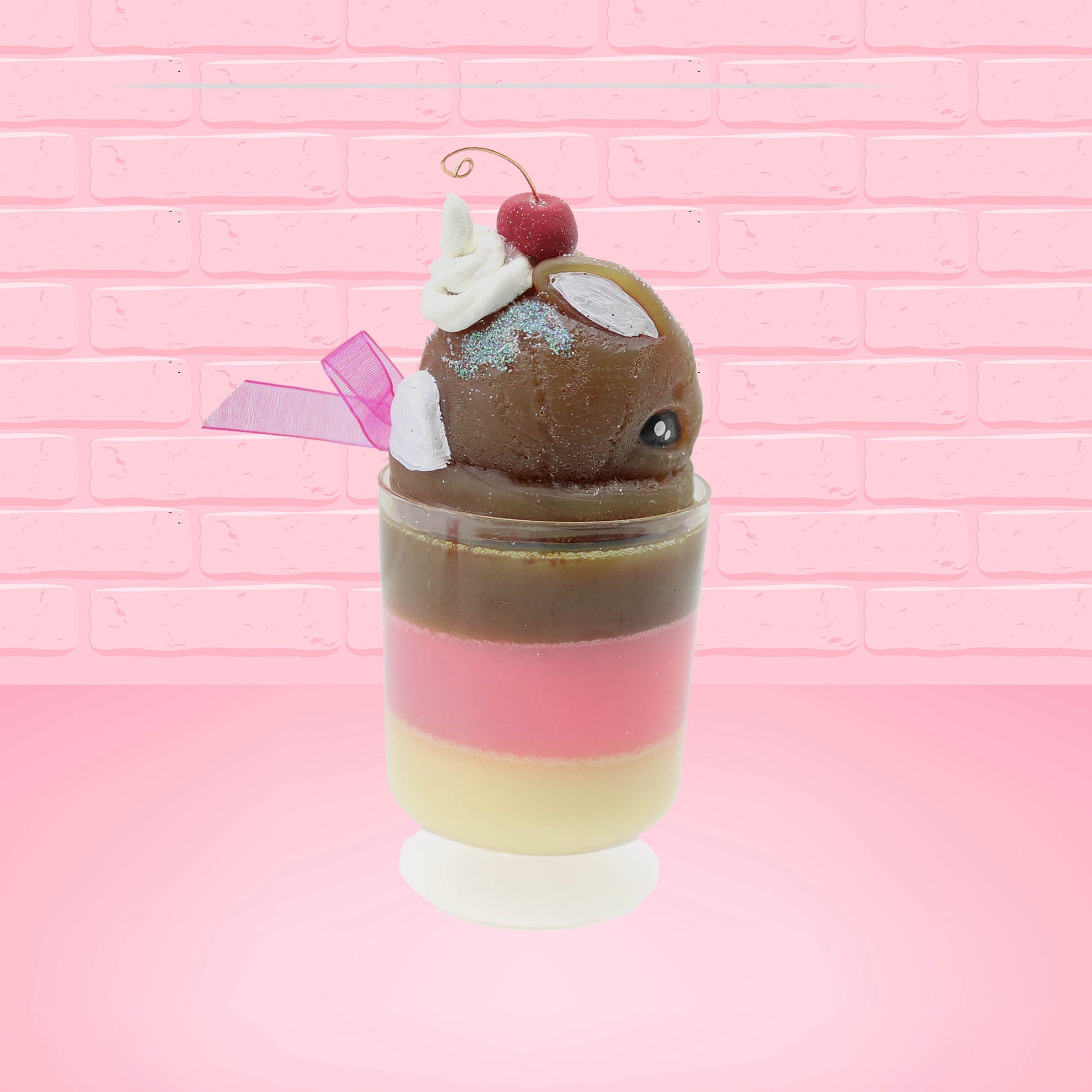 Cute Kawaii bunny tall Neapolitan three layered ice cream sundae with a cherry and swirl of whipped cream on top.  The top of the bunny is covered with white glitter, and has a pink bow.  This view is from the other side.