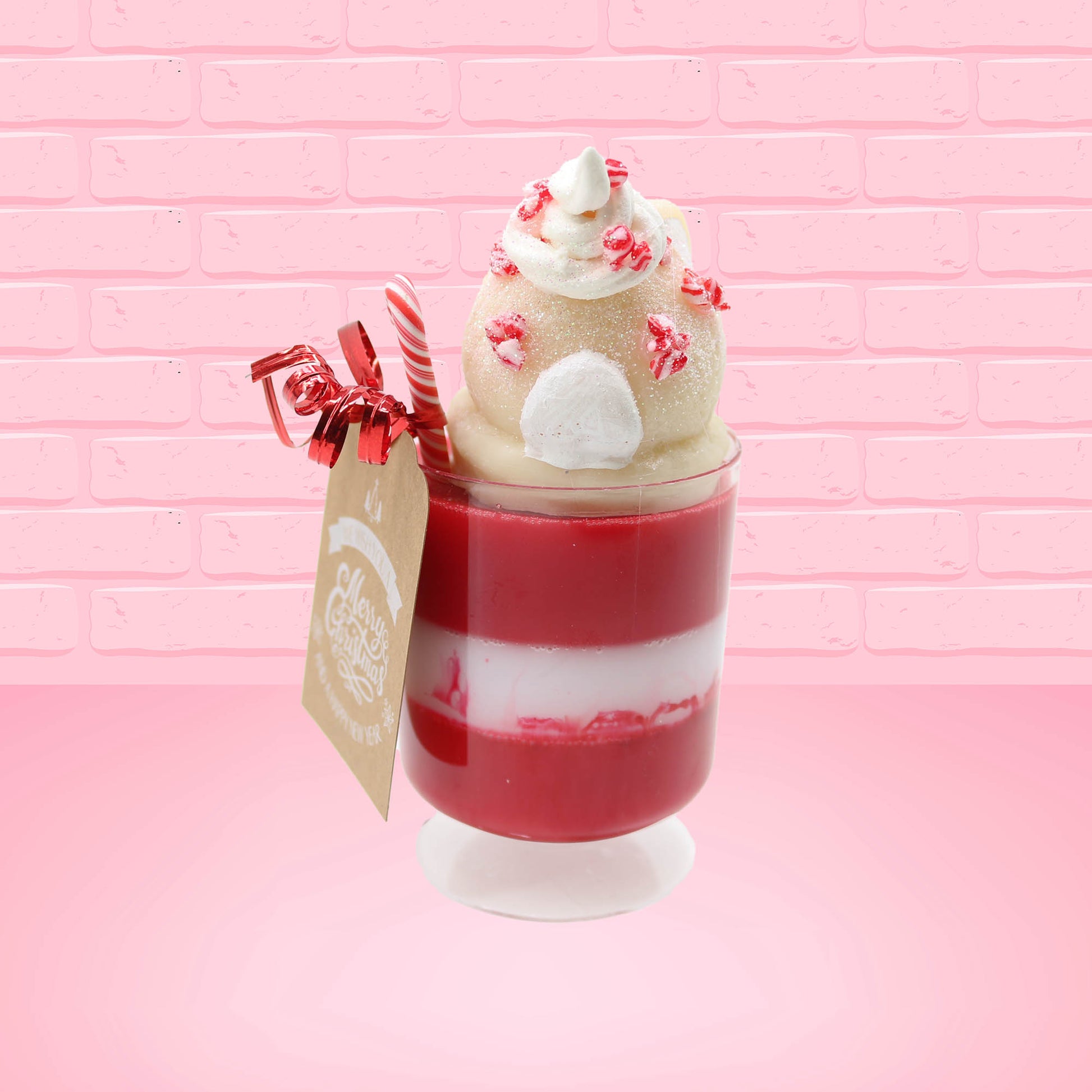 Cute kawaii bunny Peppermint Bark white ice cream tall sundae that has red and white layers in the dish and a peppermint candy cane holding a brown and white tag. The tag reads We wish you a merry Christmas and a happy new year, and the bunny has bits of peppermint candy on top as well as swirl of whipped cream. This view is from the back.