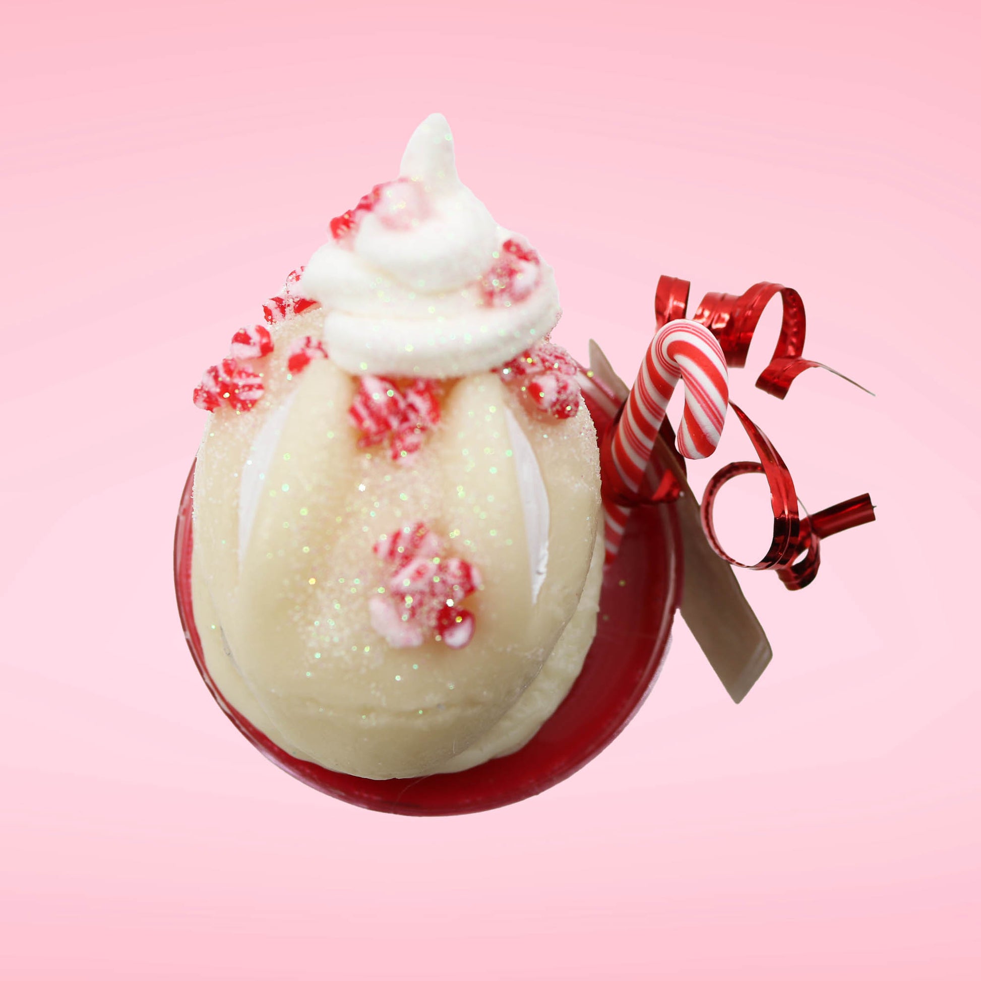 Cute kawaii bunny Peppermint Bark white ice cream tall sundae that has red and white layers in the dish and a peppermint candy cane holding a brown and white tag. The tag reads We wish you a merry Christmas and a happy new year, and the bunny has bits of peppermint candy on top as well as swirl of whipped cream. This view is from the top.