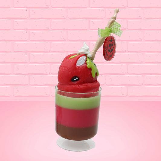 Cute kawaii bunny tall red green and brown ice cream sundae with green glaze and a swirl of whipped cream up top. In the top of the bunny is a bony finger with the poison apple acrylic keychain attached to it. This view is from the side at an angle.