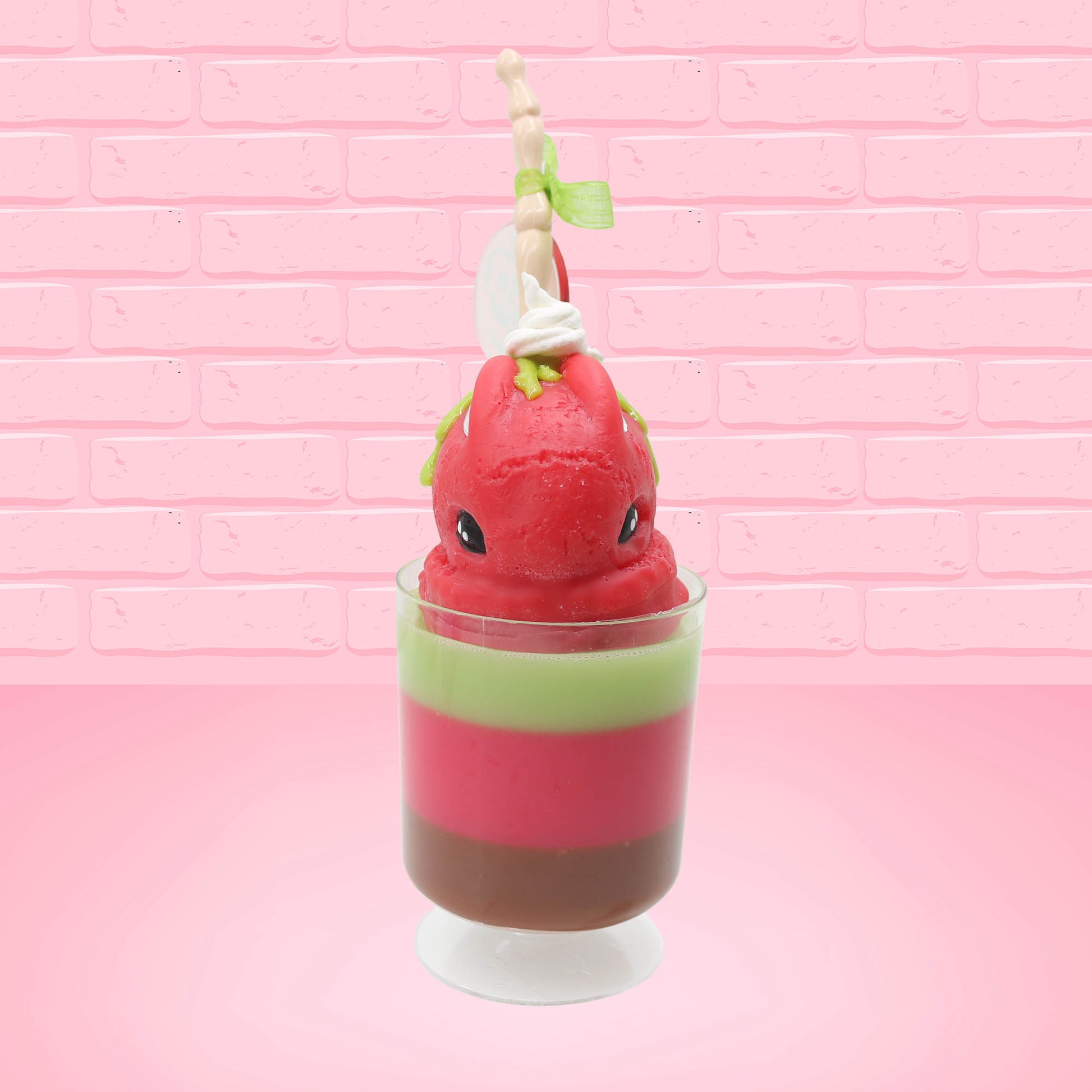 Cute kawaii bunny tall red green and brown ice cream sundae with green glaze and a swirl of whipped cream up top. In the top of the bunny is a bony finger with the poison apple acrylic keychain attached to it. This view is from the front.